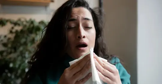 A woman sneezing