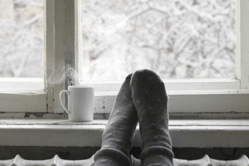 A person relaxes inside on a cold day. Why Isn’t My Furnace Heating My Entire Home?