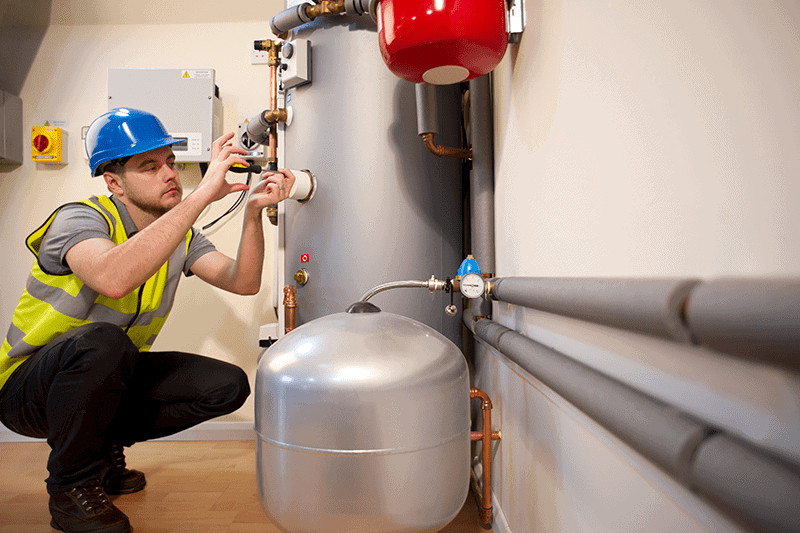 Image of a technician working on a furnace. 7 Furnace Maintenance Tips.